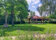 Blick über eine Wiese mit einem Pavillon im Hintergrund